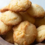 Golden brown biscuits in a wooden bowl from a keto biscuit recipe with coconut flour, showing their light and fluffy texture.